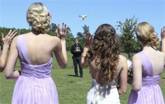 In this picture taken Saturday, April 2, 2016, drone videographer and professional photographer Coleman Jennings flies their drone for video prior to Taylor Jolly and Amy Stark's marriage during the Ranch home Chapel & Lodge in Montgomery, Texas. As weddings become a lot more sophisticated and staged, partners more and more are demanding Hollywood-style special results for the unique, jaw-dropping movie. (Edward A. Ornelas/The San Antonio Express-News via AP)