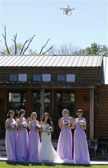 inside image taken Saturday, April 2, 2016, from kept, Lauren Elander, Morgan Mobley, Shannon Smith, Amy Stark, Ellie Herring, and Nicole Enas pose for drone video footage by drone videographer and professional photographer Coleman Jennings before Taylor Jolly and Amy Stark's wedding ceremony within Ranch home Chapel & Lodge in Montgomery, Texas. As weddings come to be more and more sophisticated and staged, couples increasingly are demanding Hollywood-style unique effects for the one-of-a-kind, jaw-dropping movie. (Edward A. Ornelas/The San Antonio Express-News via AP) RUMBO DE SAN ANTONIO OUT; NO SALES; MANDATORY CREDIT